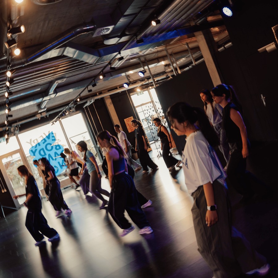 Dancers moving together across the floor during a group workshop at The Vibe Dance Studio in Zurich.